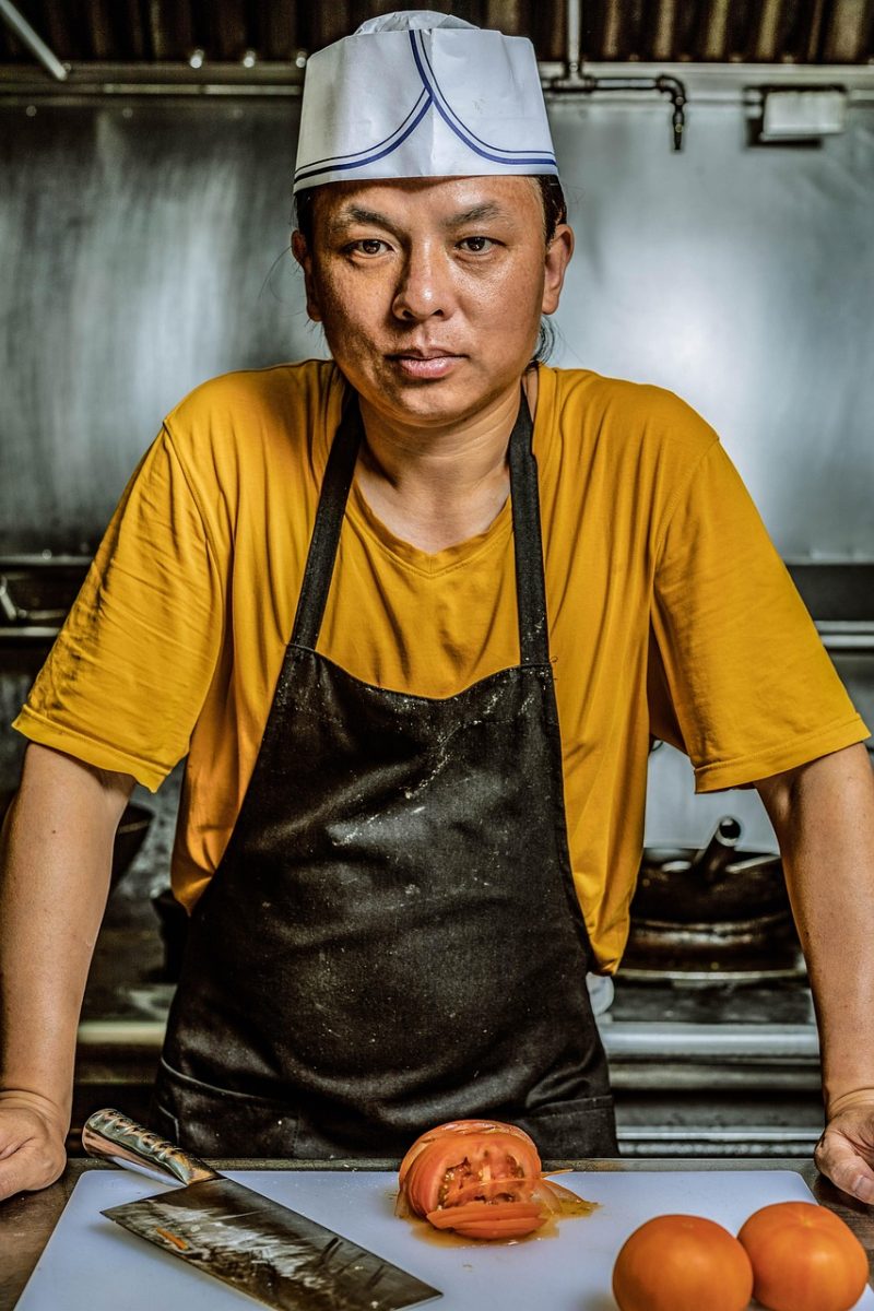 Kok i professionelt restaurantkøkken med industrikøleskab